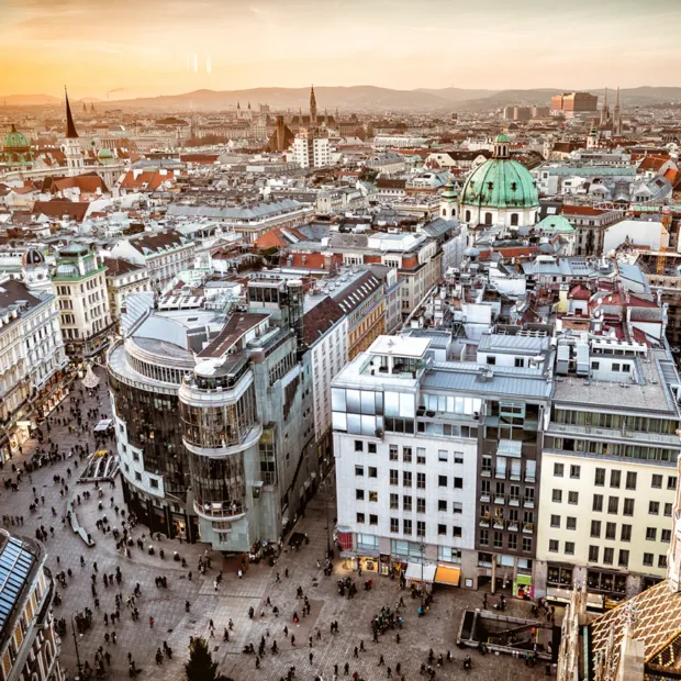 Blick über die Innenstadt von Wien mit Gebäuden und Kuppeln bei Sonnenuntergang